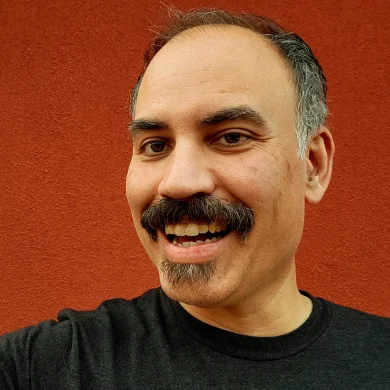 Gig Entertainer Ramp smiling in front of a textured red wall