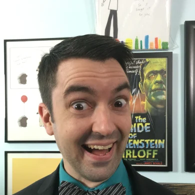 Gig Entertainer Ramp smiling with wide eyes in front of framed artwork